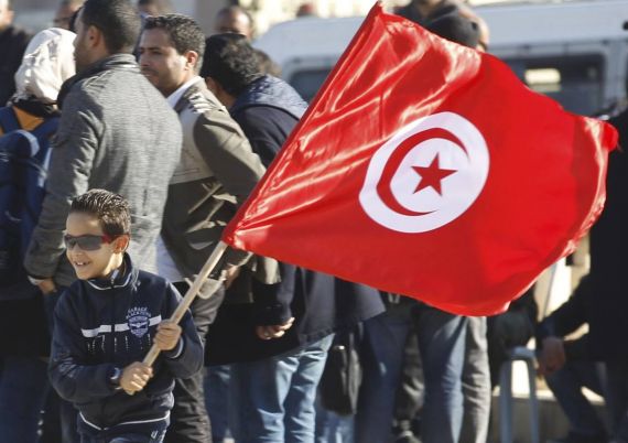 A Tunisian boy waves a flag as he runs during a rally to mark the third anniversary of the Tunisian revolution in Tunis, in this December 17, 2013 file photo. Tunisia's National Dialogue Quartet won the Nobel Peace Prize on Friday for its contribution to building democracy after the Jasmine Revolution in 2011, the Nobel Committee announced on October 9, 2015. The National Dialogue Quartet is formed by four organizations of Tunisian civil society, the Tunisian General Labour Union, the Tunisian Confederation of Industry, Trade and Handicrafts, the Tunisian Human Rights League, and the Tunisian Order of Lawyers. REUTERS/Zoubeir Souissi